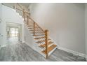 Elegant staircase features wood steps, white risers and a modern metal railing, offering a stylish transition at 5125 Isaac Dr, Charlotte, NC 28216