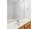 Bathroom with light countertop, wooden cabinet, large mirror, and chrome fixtures at 8263 Carob Tree Ln, Charlotte, NC 28215