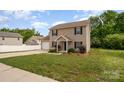 Lovely two-story home with a well-maintained lawn, inviting entrance, and attached garage at 8309 Knapp Ct, Locust, NC 28097