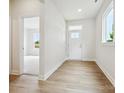 Bright foyer with wood-look flooring, white walls, and natural light streaming through the front door and window at 10113 Mamillion Dr, Huntersville, NC 28078