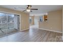 Bright living room featuring hardwood floors, slider to deck, and open access to kitchen at 1036 Plaza Walk Dr, Charlotte, NC 28215