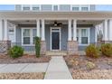 Close-up of a charming front porch with brick accents, white columns, and a welcoming entrance at 11604 Bradford Park Dr, Davidson, NC 28036