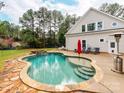 Backyard pool with stone trim, built-in spa, patio, and lush surroundings at 123 Yellow Jacket Cir, Mooresville, NC 28117