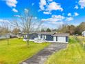 Attractive blue home with attached garage, front porch, and expansive front yard provides a serene, suburban setting at 133 Hallmark Estates Dr, Statesville, NC 28625