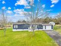 Charming blue home with a well-manicured lawn, attached garage, and inviting front porch, offering great curb appeal at 133 Hallmark Estates Dr, Statesville, NC 28625