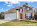 Charming two-story home with a manicured lawn and a driveway leading to an attached garage at 201 Chestnut Ave, Tega Cay, SC 29708