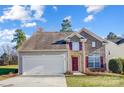 Charming two-story home with a manicured lawn and a driveway leading to an attached garage at 201 Chestnut Ave, Tega Cay, SC 29708