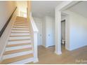 Open hallway featuring a staircase, hardwood floors, and access to a half bathroom at 3928 Craig Ave, Charlotte, NC 28211