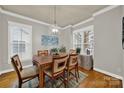 Bright dining room featuring stylish chandelier, hardwood floors and sun-filled windows at 431 Third Baxter St, Fort Mill, SC 29708