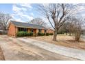 A charming single-story brick home with a long drive and a neatly kept lawn at 4815 Carriage Drive Cir, Charlotte, NC 28205