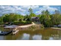 Beautiful waterfront property featuring a home and dock with lovely lake views surrounded by lush greenery at 6233 Riviera Run Estates Dr, Hickory, NC 28601