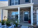 Inviting front porch with stone accents, white columns, and a stylish front door at 7711 Bainbridge Rd, Sherrills Ford, NC 28673