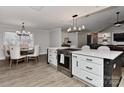 Open kitchen featuring a stainless steel oven, white cabinetry, and a dining area bathed in natural light at 9414 Machado Dr, Indian Trail, NC 28079