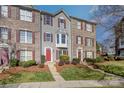 A well-maintained townhome showcasing a blend of brick and siding, complemented by lush greenery and a walkway at 9534 Blossom Hill Dr, Huntersville, NC 28078