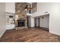 Spacious living room featuring a soaring stone fireplace, hardwood floors, and a view of the upper level at 1027 21St Ne Ave, Hickory, NC 28601