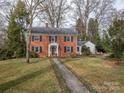 Charming two-story brick home with classic design and mature landscaping creating a welcoming curb appeal at 1120 Cumberland Ave, Gastonia, NC 28054