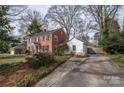 Side view showing a brick house with a white detached garage and a private driveway and yard with patio furniture at 1120 Cumberland Ave, Gastonia, NC 28054