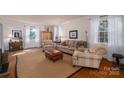 Bright living room with hardwood floors, neutral walls, large windows, and comfortable furniture for relaxation at 1120 Cumberland Ave, Gastonia, NC 28054