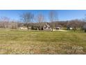 Sprawling lot showcases this inviting home with mature trees, a circular driveway, and ample parking at 125 Round Tuit Ln, Mt Ulla, NC 28125