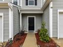 Inviting front entrance with a black door, manicured landscaping, and neutral siding at 1365 Eagle Claw Dr, Kannapolis, NC 28083