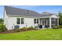 Backyard view featuring a screened porch, patio, and landscaping at 2022 Mantle Ridge Dr, Indian Trail, NC 28079