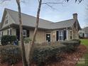 Stone and siding home featuring dark shutters, an arched window, and mature landscaping creating a warm aesthetic at 2656 Polo Club Blvd, Matthews, NC 28105