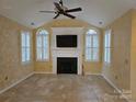 Bright living room featuring a fireplace with built-ins, arched windows, and a ceiling fan at 2656 Polo Club Blvd, Matthews, NC 28105