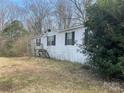 Single-story home with white siding and dark shutters surrounded by trees at 282 Dixon Rd, Lancaster, SC 29720
