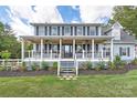 Inviting covered front porch with hanging plants, fans, and seating to enjoy outdoor living and landscaped front yard at 3929 Wexford Ln, Denver, NC 28037