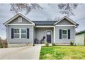 Charming gray home with black shutters, inviting front porch and well-maintained landscaping at 611 N York St, Gastonia, NC 28052