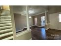 Inviting living room with columns, hardwood floors, large windows, and great natural light at 8703 Ellington Park Dr, Charlotte, NC 28277