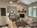 Bright living room with a stone fireplace, hardwood floors, and abundant natural light at #92 Silver Trace Ln, Denver, NC 28037