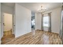 Bright dining room with wood floors, modern lighting, and a view of the kitchen and powder room at 11426 Savannah Creek Dr, Charlotte, NC 28273