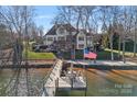 View of backyard leading to the lake; the dock is nicely framed and the lake is very inviting at 122 N Longfellow Ln, Mooresville, NC 28117