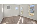 Well-lit bedroom featuring wood-look floors and three windows allowing plenty of natural light at 13705 Roderick Dr # 194, Huntersville, NC 28078