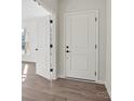 Bright entryway featuring wood-look floors and white paneled doors with black hardware at 13705 Roderick Dr # 194, Huntersville, NC 28078