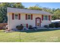 Exterior view of a two-story home with light yellow siding, red shutters, and a green lawn at 1501 Fern Forest Dr, Gastonia, NC 28054