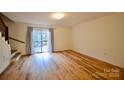 Spacious living room featuring laminate flooring, staircase, and sliding glass door to the deck at 1536 Cooper Ave, Kannapolis, NC 28081
