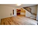 Open-concept living room featuring wood-look floors, stairs, and views into the kitchen at 1536 Cooper Ave, Kannapolis, NC 28081