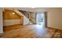 Open-concept living room featuring wood-look floors, stairs, and glass sliding doors to the exterior at 1536 Cooper Ave, Kannapolis, NC 28081