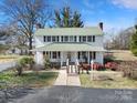 Charming two-story home with a welcoming front porch and lush landscaping at 1612 Forum Ln, Iron Station, NC 28080