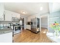 Bright kitchen featuring stainless steel appliances, white cabinets, and hardwood floors at 285 Fryling Sw Ave, Concord, NC 28025