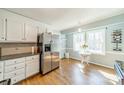 Eat-in kitchen showcasing stainless steel refrigerator, granite counters, and bright windows at 285 Fryling Sw Ave, Concord, NC 28025
