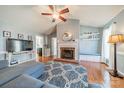 Open living room featuring a ceiling fan, fireplace, and hardwood floors at 285 Fryling Sw Ave, Concord, NC 28025