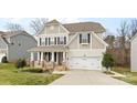 Charming two-story home features a covered front porch and a two-car garage at 3114 Woodlands Creek Dr, Monroe, NC 28110