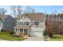 Charming two-story home features a covered front porch and a two-car garage at 3114 Woodlands Creek Dr, Monroe, NC 28110