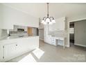 Bright kitchen featuring white cabinets, countertop seating and modern light fixture at 4210 Wrangler Sw Dr, Concord, NC 28027