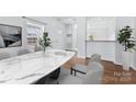 Another view of the open dining room with a modern marble table set at 590 Main Sw St, Concord, NC 28027