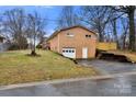 Rear view of brick home with garage and a drive way at 7047 Cheyenne Dr, Charlotte, NC 28262