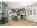 Bright kitchen with an island, stainless steel appliances, stylish cabinets, and wood-look flooring at 7407 Forney Hill Rd, Denver, NC 28037